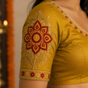 Kerala Kolam sleeve embroidery design with floral Aari work, zari and stone embellishments