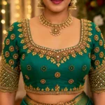 Emerald green Aari bridal blouse front view with gold sunburst embroidery and mirror work