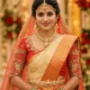Red bridal Aari blouse front view with antique gold floral embroidery and Maggam work