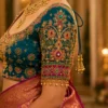 Close-up of Royal Peacock Emerald Bridal Aari Blouse elbow sleeve showcasing floral motifs, emerald stones, ruby accents, and handcrafted Aari embroidery.