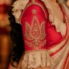 Royal Red Bridal Aari Blouse sleeve showcasing lotus-inspired Aari embroidery, pearl lace border, premium Maggam Work, and bridal craftsmanship.