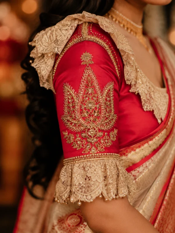 Royal Red Bridal Aari Blouse sleeve showcasing lotus-inspired Aari embroidery, pearl lace border, premium Maggam Work, and bridal craftsmanship.